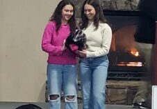 Katie and Maddie Allen hold the ceremonial helmet after being named the 23- 24 Savage Squirrels.