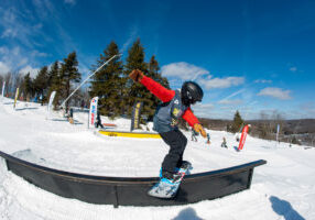 A DCWST Snowboard Team member competes in the park at a USASA event.