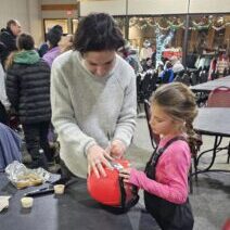 Megan McJames signs the helment of DCWST athlete Sawyer Guidera. 